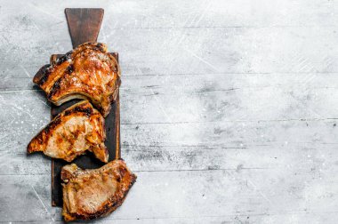 Kesme tahtası üzerinde ızgara domuz biftek. Rustik bir arka plan üzerinde .