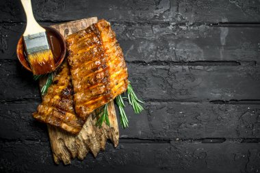 Soslu ızgara kaburga. Siyah bir rustik arka planda.