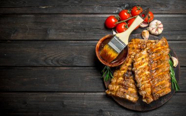 Izgara kaburga sos, otlar ve baharatlar ile. Ahşap bir arka plan üzerinde.