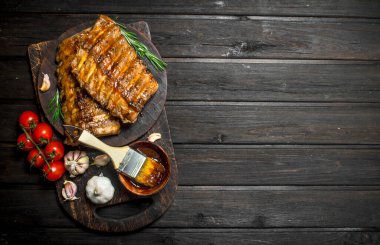 Izgara kaburga sos, otlar ve baharatlar ile. Ahşap bir arka plan üzerinde.