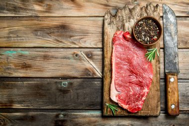 Baharat ile ham mermer sığır biftek. Ahşap bir arka plan üzerinde.