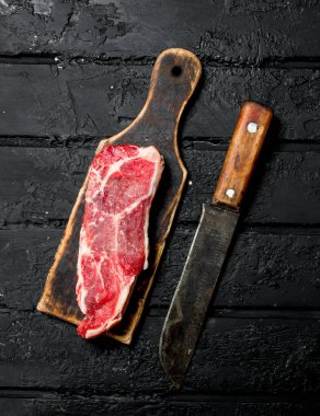 Çiğ biftek. Siyah rustik arka planda.