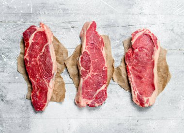 Ham mermer sığır biftek. Rustik bir arka plan üzerinde.