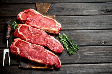 Ham mermer sığır biftek. Ahşap bir arka plan üzerinde.