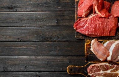 Çiğ et. Domuz ve sığır eti farklı türde. Ahşap bir arka plan üzerinde.