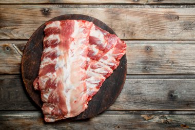 Kesme tahtası üzerinde ham kaburga. Ahşap bir arka plan üzerinde.