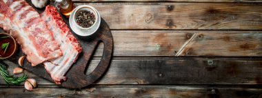 Baharat ve otlar ile ham kaburga. Ahşap bir arka plan üzerinde.