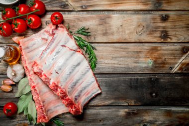 Baharat ve otlar ile ham kaburga. Ahşap bir arka plan üzerinde.