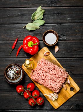 Çiğ kıyma sebze ve baharatlar ile. Ahşap bir arka plan üzerinde.