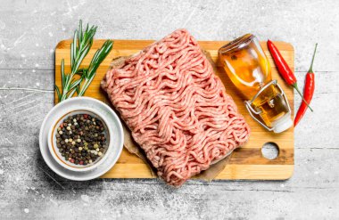 Çiğ kıyma baharat ve otlar ile. Rustik bir arka plan üzerinde.