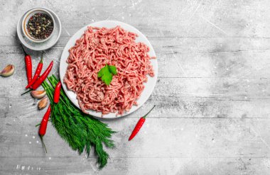 Çiğ kıyma baharat ve otlar ile. Rustik bir arka plan üzerinde.