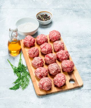 Baharat ve güzel kokulu dereotu ile ham sığır eti köfte. Rustik bir arka plan üzerinde.