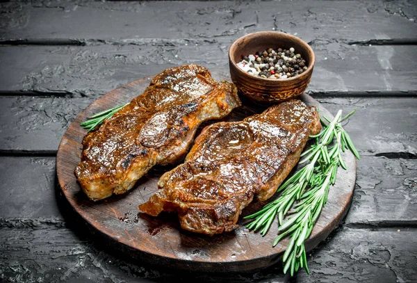 牛肉のグリル ステーキ スパイスとハーブ 素朴な黒地に — ストック写真