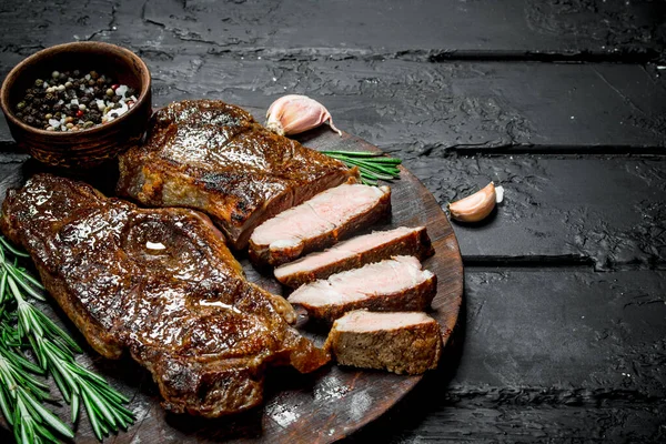 牛肉のグリル ステーキ スパイスとハーブ 素朴な黒地に — ストック写真