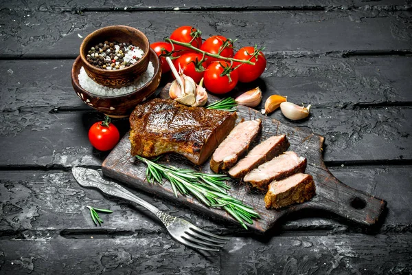 牛肉のグリル ステーキ ローズマリーとトマト 素朴な黒地に — ストック写真