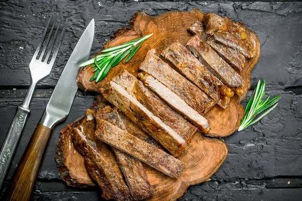 スライスした牛肉のグリル ステーキ ローズマリー 素朴な黒地に — ストック写真