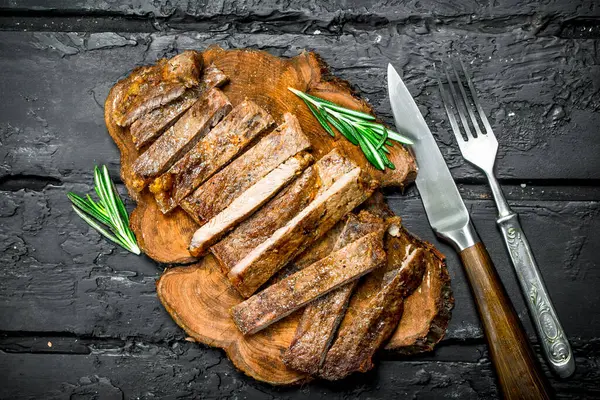 スライスした牛肉のグリル ステーキ ローズマリー 素朴な黒地に — ストック写真