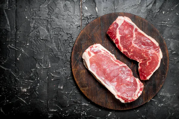 Filetes Carne Cruda Tabla Cortar Sobre Fondo Rústico Negro — Foto de Stock