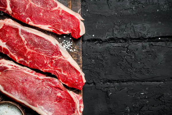 Filetes Crudos Carne Jugosa Con Sal Sobre Fondo Rústico Negro — Foto de Stock