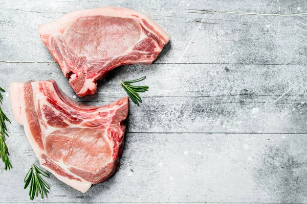 stock image Raw pork steaks on the bone. On a rustic background.