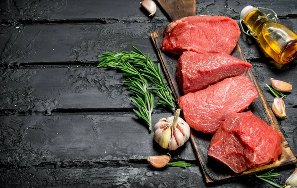 Carne Crua Pedaços Carne Com Alho Alecrim Fundo Rústico Preto — Fotografia de Stock