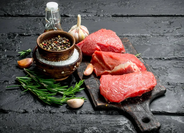 Carne Crua Pedaços Carne Com Especiarias Ervas Fundo Rústico Preto — Fotografia de Stock