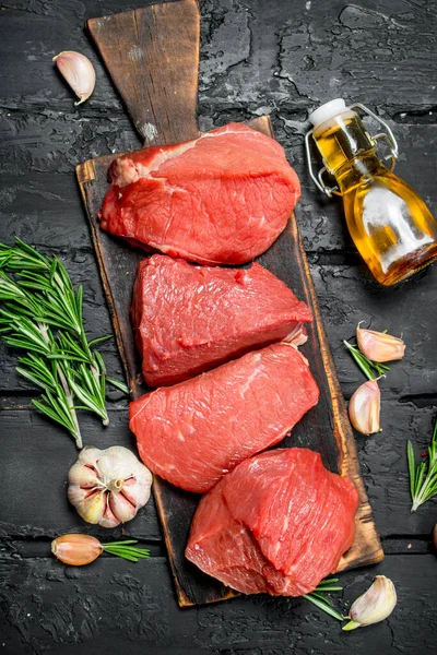 Rauw Vlees Stukken Van Rundvlees Met Knoflook Rozemarijn Een Zwarte — Stockfoto