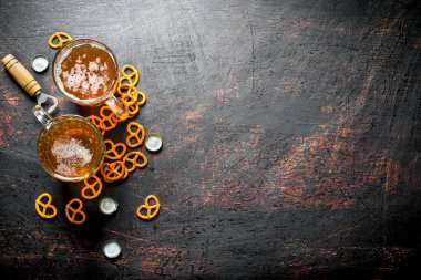 Bardakve atıştırmalıklarda bira. Koyu rustik arka plan üzerinde