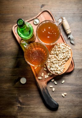 Tabakta kupave fıstıkla bira. Ahşap arka planda