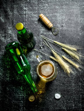 Şişe ve çivili bira bardağı. Siyah rustik arka plan üzerinde