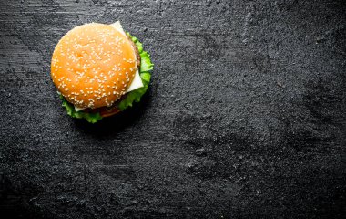 Bir sulu sığır burger. Siyah rustik arka plan üzerinde