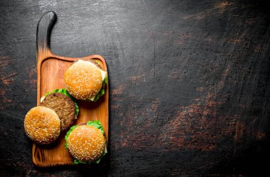 Sulu sığır eti ile Burgers. Koyu rustik arka plan üzerinde