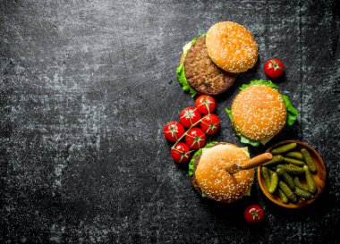 Bıçaklı hamburger, salatalık ve kiraz. Rustik arka planda