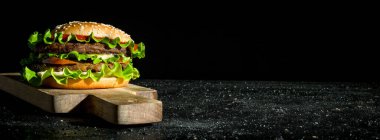 Sığır eti ve sebzeli burger. Rustik arka planda