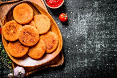 Kekik, sarımsak ve domates soslu bir tabakta balık pirzola. Siyah rustik arka plan üzerinde