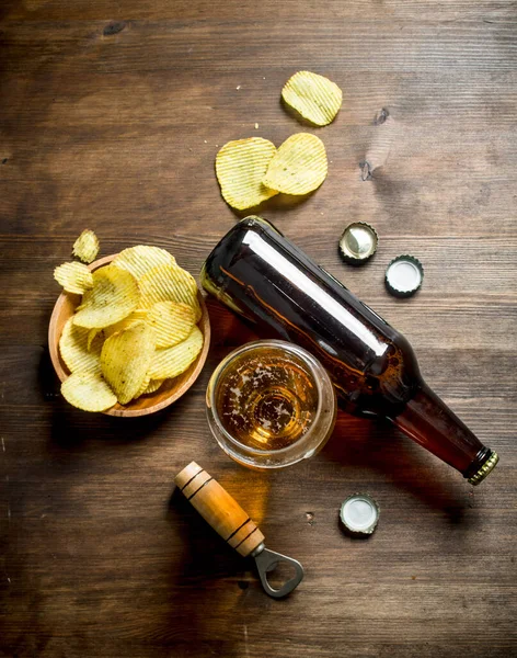 stock image Beer and chips in the bowl. On wooden background