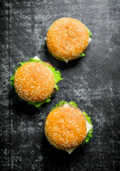 牛肉と野菜のハンバーガー 黒い素朴な背景に — ストック写真