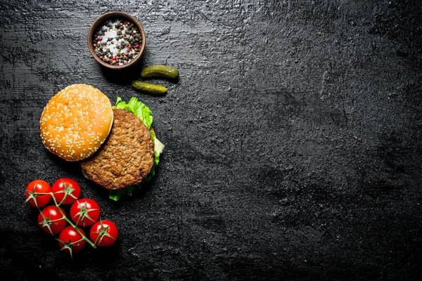 Domatesli burger, salatalık ve baharat. Rustik arka planda