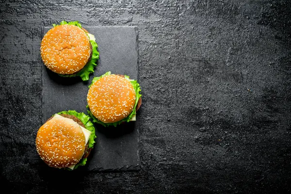チーズのハンバーガー 黒い素朴な背景に — ストック写真