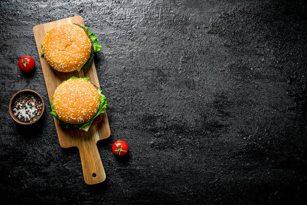 Burgers with salt and pepper in bowl. On black rustic background