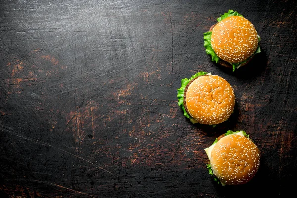 stock image Burgers with beef and vegetables. On dark rustic background