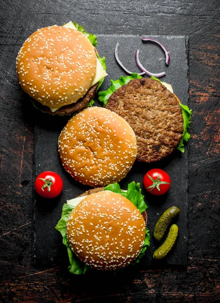 トマト キュウリのハンバーガー 黒い素朴な背景に — ストック写真