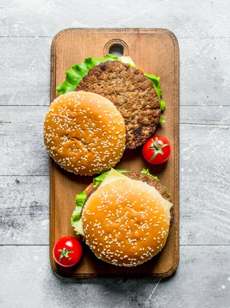 ジューシーな牛肉とトマトのハンバーガー 白い木製の背景に — ストック写真