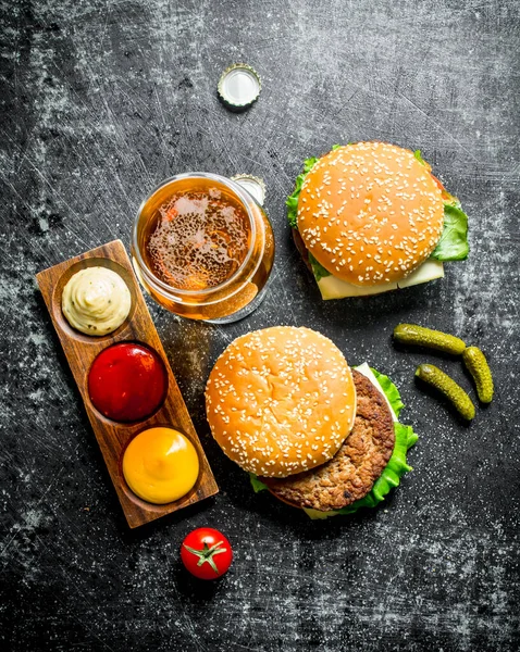 Burger Pivem Omáčkami Okurky Černém Venkovním Pozadí — Stock fotografie