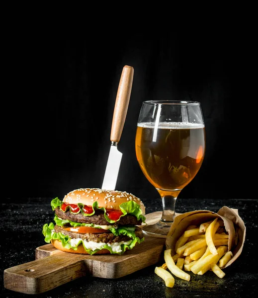 Hamburguesa Con Cuchillo Papas Fritas Cerveza Vaso Sobre Fondo Rústico —  Fotos de Stock