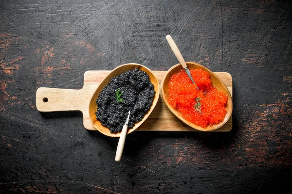 切割板上碗中的红色和黑色鱼子酱 在黑暗的质朴背景 — 图库照片