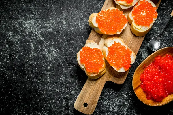 Sanduíches Com Caviar Vermelho Uma Tábua Corte Madeira Fundo Rústico — Fotografia de Stock