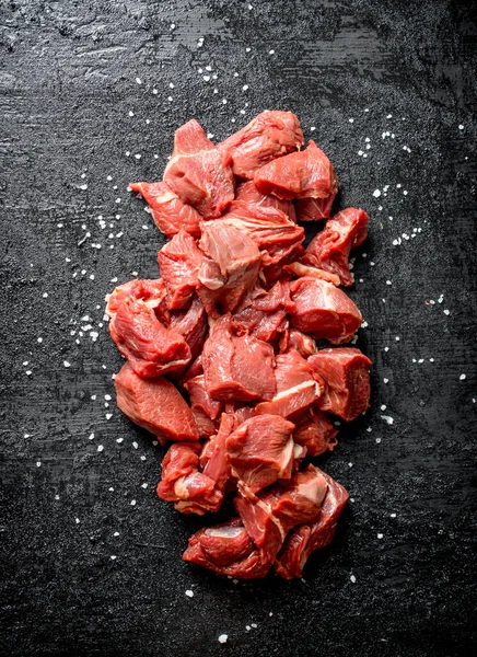 Carne Crua Fatiada Com Grãos Sal Fundo Rústico Preto — Fotografia de Stock