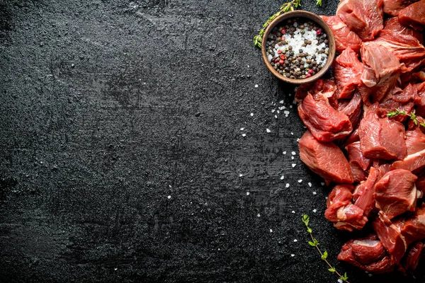 在碗中切生牛肉 切百里香和调味料 在黑色质朴的背景 — 图库照片