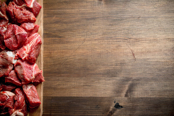 Sliced raw beef on a cutting Board. On wooden background